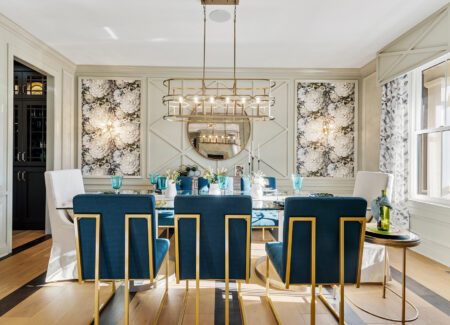 exquisite dining room with navy blue chairs and art displayed on the wall