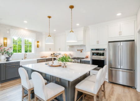 beautiful kitchen with white cabinets up top and gray cabinets on the bottom and on the island